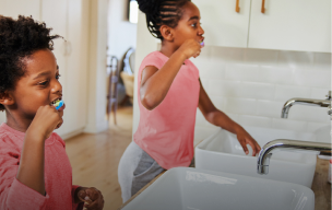 kvinde sidder foran en bærbar computer og smiler